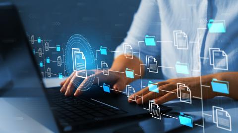 A person types on a laptop with a graphic overlaid of a database