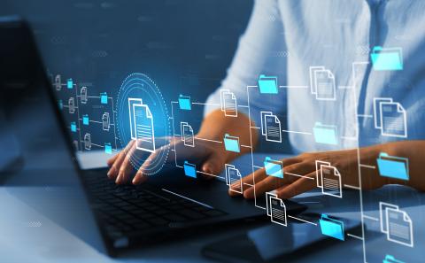 A person types on a laptop with a graphic overlaid of a database